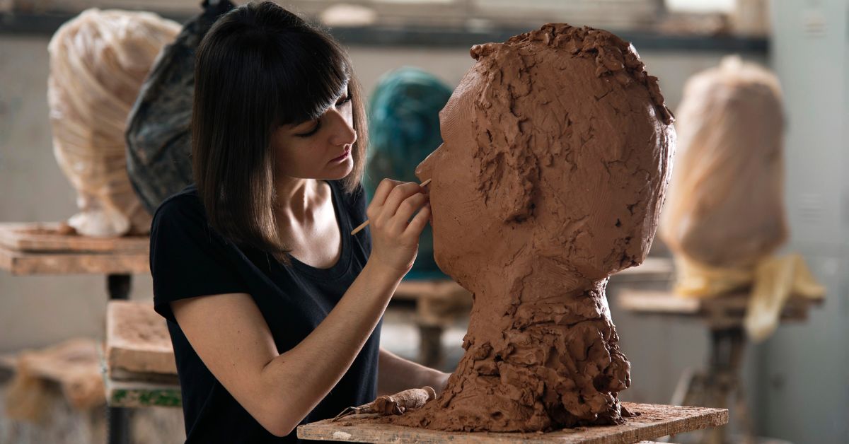 Skulptør arbejder på en skulptur af ler